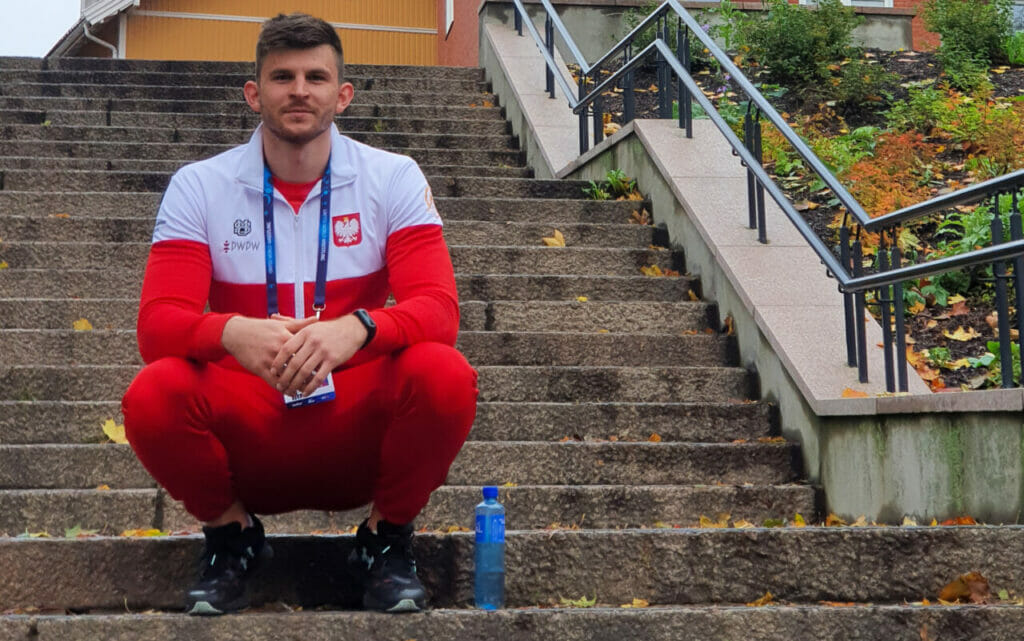 Sportowiec siedzi na schodach w Krakowie.