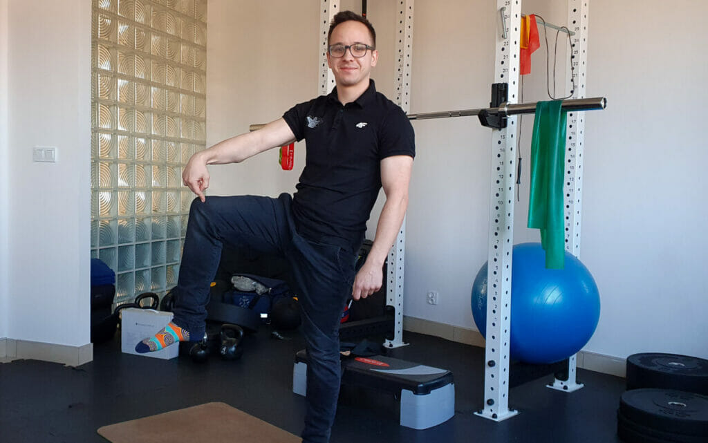 Mężczyzna ćwiczący na macie w sali gimnastycznej w Krakowie.